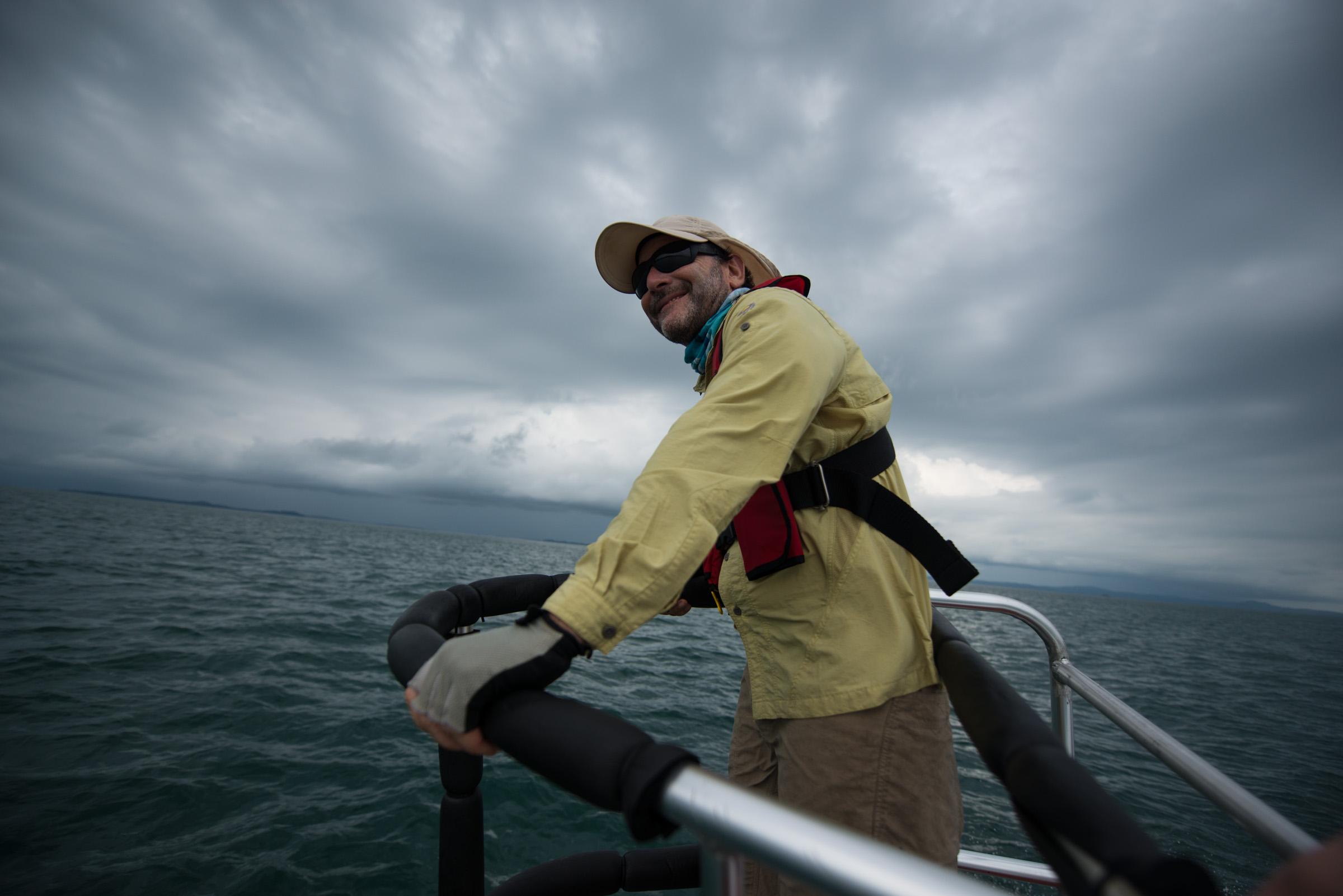 Marine biologist surveying water while tracking humpback whales