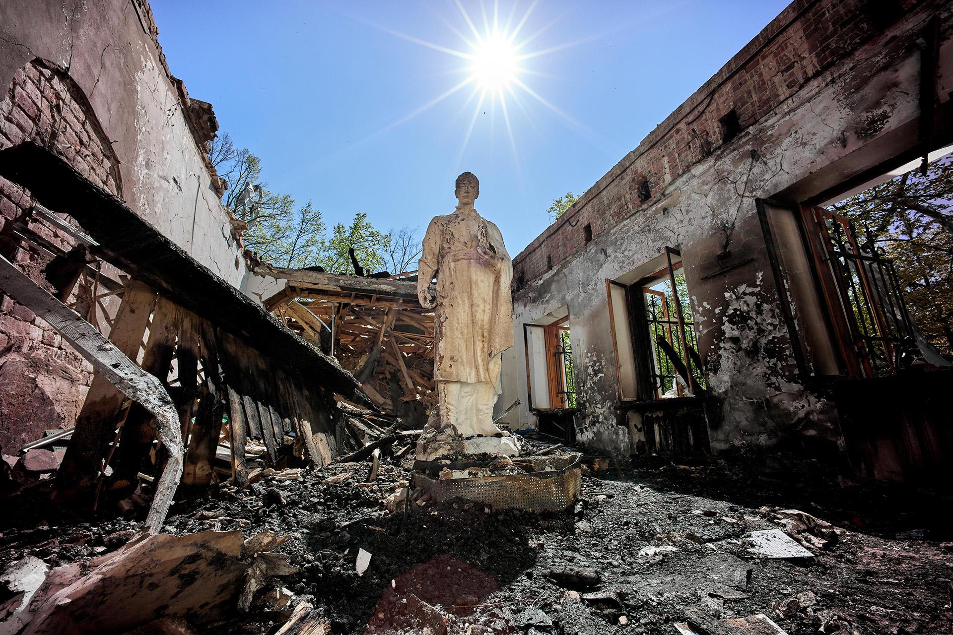 Low-angle view of a marble sculpture standing among the ruined remains of a museum