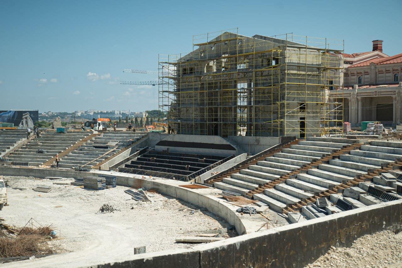 View of a scaffolded building under construction on top of an ancient amphitheater