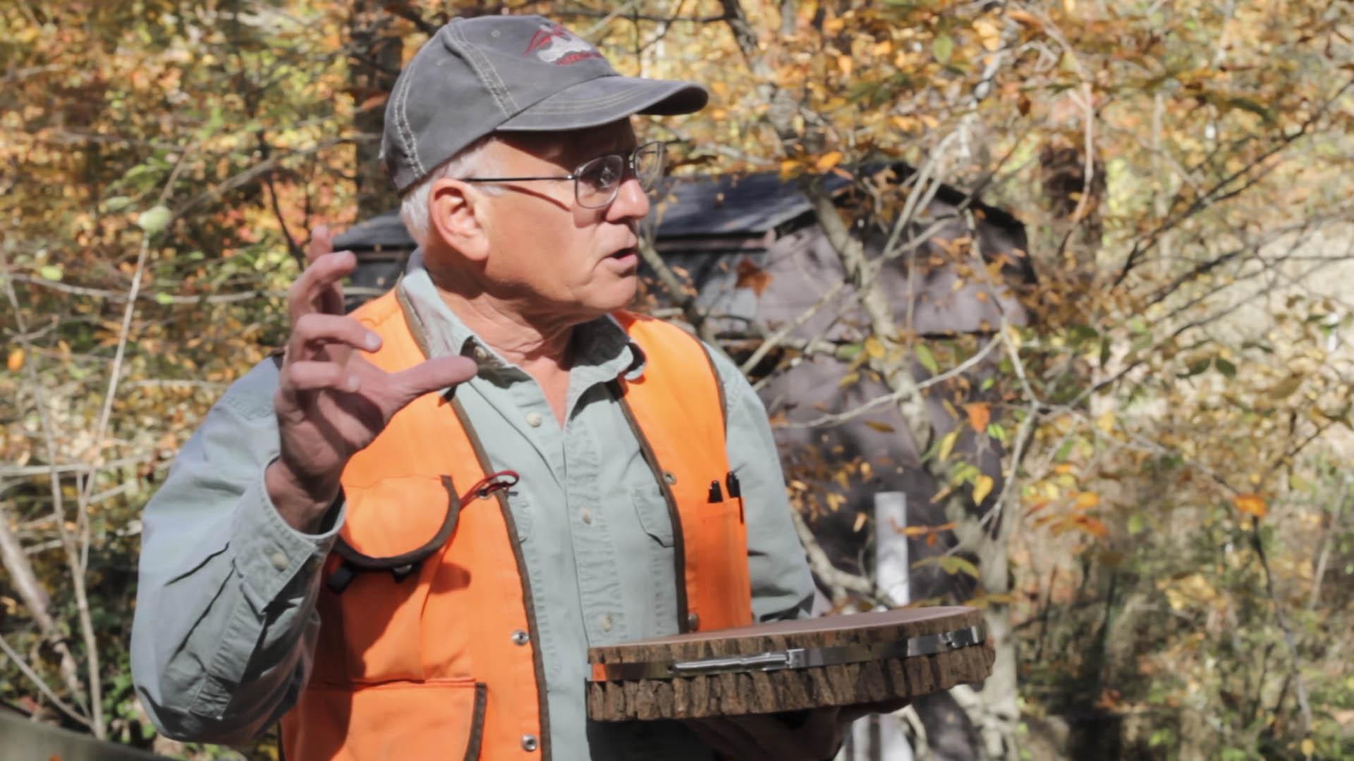 Ecologist holding tree cross section with dendrometer band around it