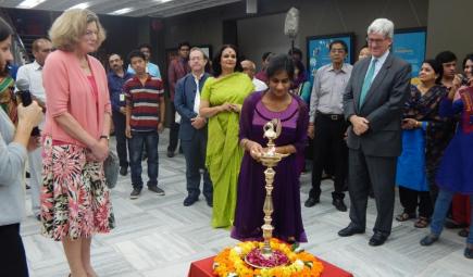 Curator lighting candle at ceremonial opening for exhibit