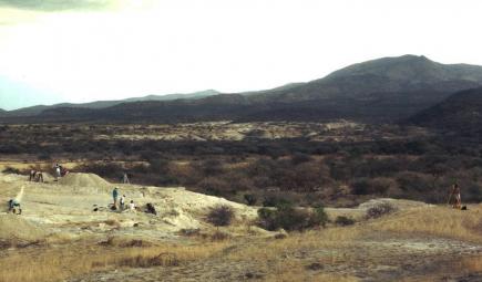 A landscape with people in the foreground.