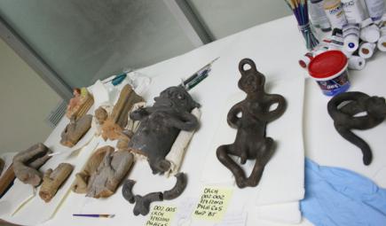 Small figurine artifacts on table in preparation for restoration