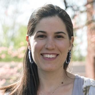 Portrait of a white woman with brown hair smiling.