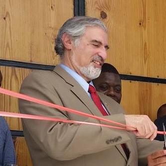 Cutting tape with dignitaries at opening of new cultural center
