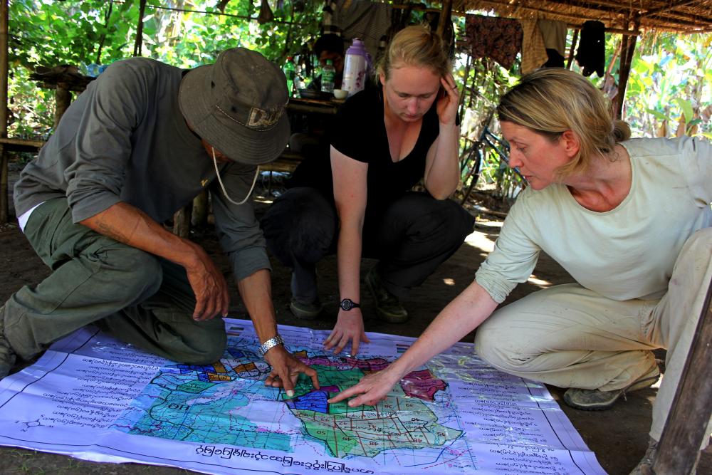 Forest Officer Than Shwe, graduate student Christie Sampson, and Mel Songer discuss land use in a high human-conflict area near the village of Thay Aye Ye in Taikkyi Township, Myanmar. Photo credit Christie Sampson.