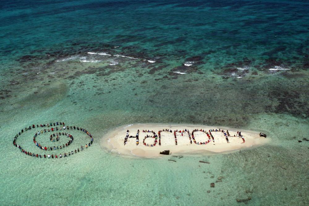 HR4HP collaborated with Spectral Q Aerial Art to create a message of hope on tiny Sergeants Caye, which is now almost fully submerged at high tide. Credit: Lou Dematteis / Spectral Q.