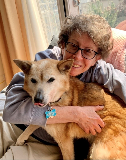 Carolyn sits with her dog.