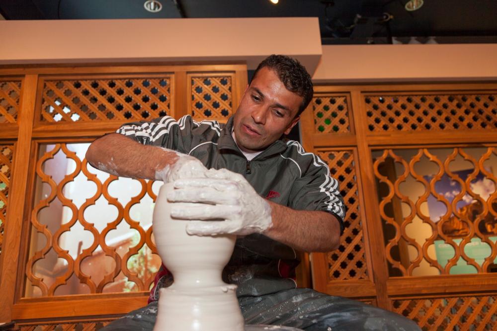 Artist making pots in the exhibition.