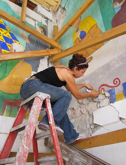 Painting conservator Viviana Dominguez, project leader for the Holy Trinity murals conservation project, takes measure of cracks on Philome Obin's Last Supper. Photo credit Stephanie Hornbeck.